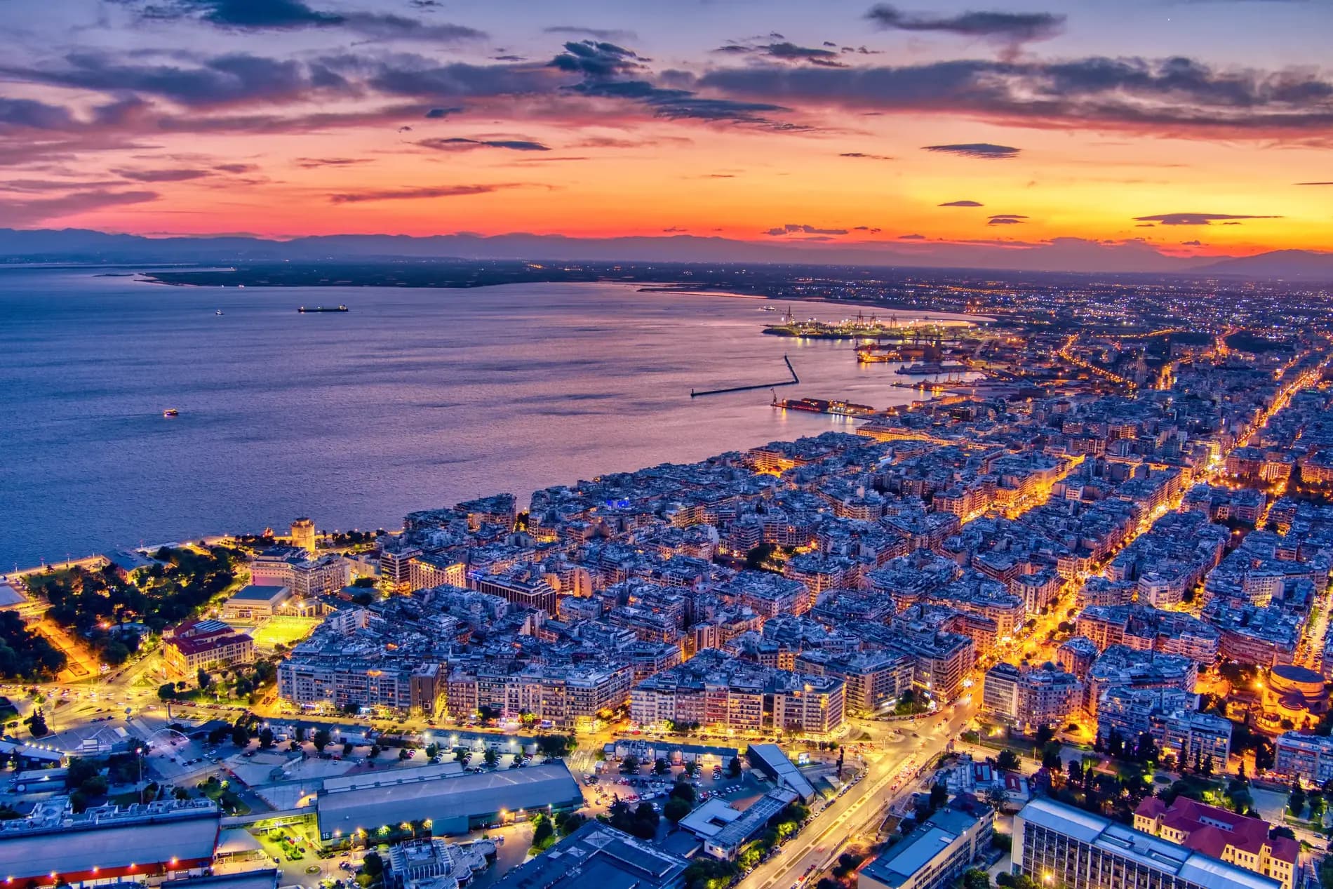 Thessaloniki bay at dusk, with the illuminated waterfront stretching around the Thermaic Gulf